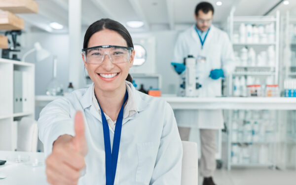 portrait of a young scientist showing thumbs up in a lab