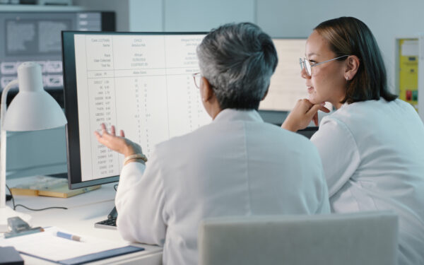 science, hospital and women on computer for research, medical report and data analytics in laboratory. healthcare, teamwork and female scientist in discussion for analysis, results and biotechnology