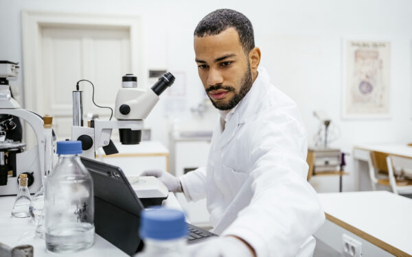 confident mixed race male student in university laboratory classroom